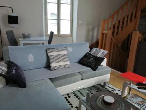 a living room with a blue couch with pillows at Bord Charente face Pôle Magelis - T2b Triplex in Angoulême