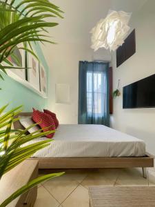 Un dormitorio con una cama y una planta. en Piave House - Pisa, en Pisa