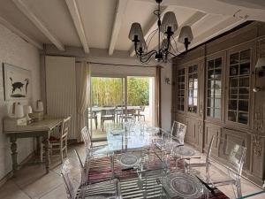 a dining room with a glass table and chairs at Maison de vacances, Piscine & Plage à pied in La Teste-de-Buch