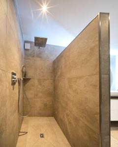 a shower with a glass door in a bathroom at Ferienhaus Waldblick mit Whirlpool und Sauna in Hellwege +23 photos