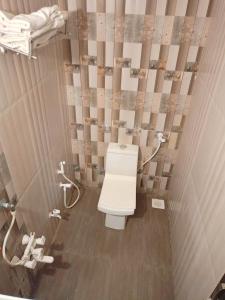 a bathroom with a white toilet in a stall at The Sky Comfort - Hotel The Heaven, Dwarka in Dwarka