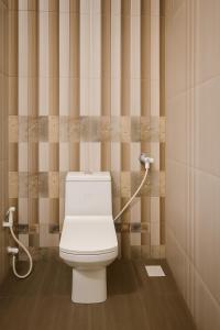 a bathroom with a white toilet in a stall at The Sky Comfort - Hotel The Heaven, Dwarka in Dwarka +7 photos