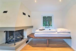 a bedroom with a bed and a fireplace at Ferienhaus Waldblick mit Whirlpool und Sauna in Hellwege