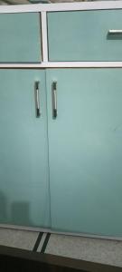 two white cabinets with glass doors on a counter at Hotel Radhe in New Delhi