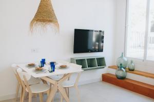 una mesa blanca y sillas en una habitación con TV en Apartamento C, en Cala d´Or