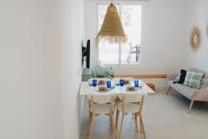 Una sala de estar con una mesa y sillas blancas. en Apartamento C, en Cala d´Or