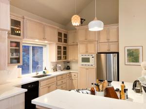 a kitchen with white cabinets and a sink and a refrigerator at Boom Chalet Yosemite in Oakhurst