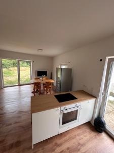 a kitchen with white cabinets and a table with chairs at Cozy Ground Floor Apartment in Lüssum