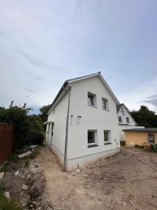 a white house is being built in a yard at Cozy Ground Floor Apartment in Lüssum