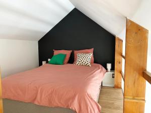Un dormitorio con una cama con sábanas y almohadas naranjas. en Le Zen Kyoto, en Lambersart