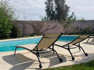 deux chaises assises à côté d'une piscine dans l'établissement Maison proche Vaison la Romaine, à Saint-Romain-en-Viennois 2 autres photos
