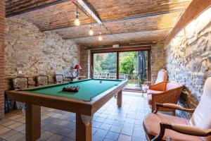 a pool table in a room with a stone wall at Gîte du Relais de l'Ourthe in Jupille