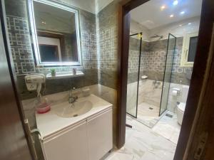 un baño con lavabo y ducha en Grand Luxury Apartments - Downtown Cairo, en El Cairo