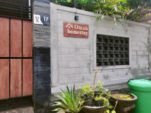 a white brick building with a sign on it at Homestay Omah in Tabanan +3 photos