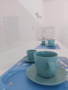 a table topped with two cups and a sink at Vulcano Etna Mare in Giardini Naxos