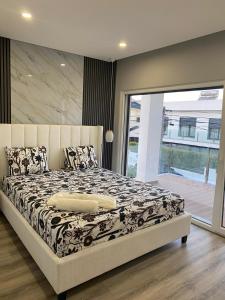 Un dormitorio con una cama con un edredón blanco y negro. en MoradiaT4 com piscina aquecida, en Arrentela 54 fotos más