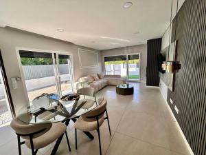 a living room with a glass table and chairs at MoradiaT4 com piscina in Arrentela