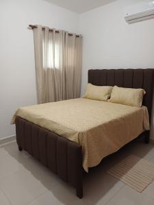 a bed in a bedroom with a brown bed frame at Sunset Apartment Beach Residences Steps from the Beach in Puerto Plata