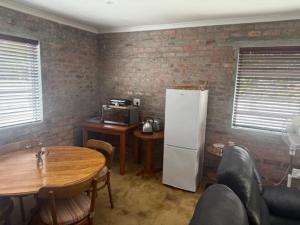 a kitchen with a table and a white refrigerator at Classic Air B&B in Pearly Beach