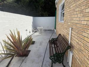 a bench sitting on a patio next to a building at Classic Air B&B in Pearly Beach