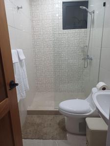 a bathroom with a shower with a toilet and a sink at Sunset Apartment Beach Residences Steps from the Beach in Puerto Plata