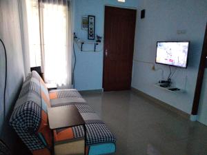 a living room with a couch and a television at Homestay Omah in Tabanan