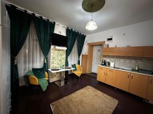 a kitchen with a table and some chairs and a table at Tobacco Sforii Residence in Braşov