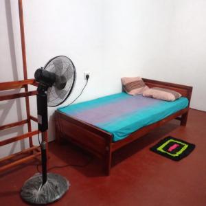 a bedroom with a bed with a fan next to a staircase at Leeostar Homestay & Safari in Horuwila