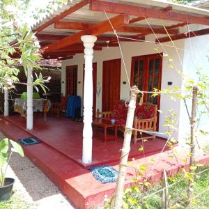 a small house with a red deck at Leeostar Homestay & Safari in Horuwila