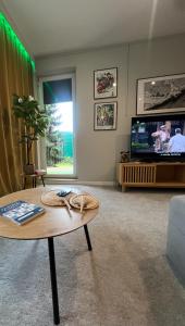 a living room with a table and a tv at EUROPA22 - Hostel Coffee Home lub cały apartament in Tomaszów Mazowiecki