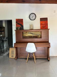 un piano en bois avec une horloge sur un mur dans l'établissement Departamento Amplio a cercanías del Rio, à Posadas