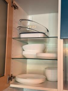 a cabinet filled with white plates and bowls at La Perle du Donon - Col du Donon - Grandfontaine in Grandfontaine +23 photos