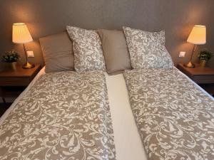 a bed with two pillows and a blanket on it at La Perle du Donon - Col du Donon - Grandfontaine in Grandfontaine
