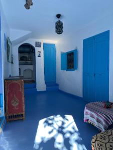 a blue room with blue doors and a bed at Dar Onsar in Chefchaouene