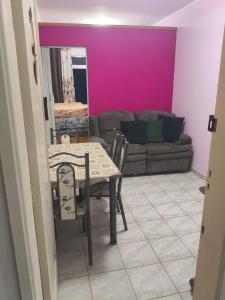 Kit do Rei - Boqueirão في برايا جراندي: غرفة طعام مع طاولة وأريكة