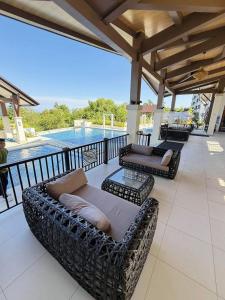 eine Terrasse mit Sofas und einem Pool in der Unterkunft Peaceful Panglao Escape for Families & Couples in Dao