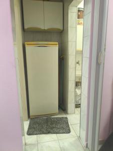 Kit do Rei - Boqueirão في برايا جراندي: ثلاجة صغيرة في مطبخ بأرضية من البلاط