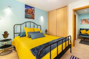 a bedroom with a yellow bed and a chair at BnB Homes Coastal Pearl Apartment with 2 Pools near to Falesia Beach in Albufeira +24 photos