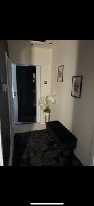 ein Wohnzimmer mit einem Tisch und einer Vase aus Blumen in der Unterkunft Black&White Deluxe in Miskolc