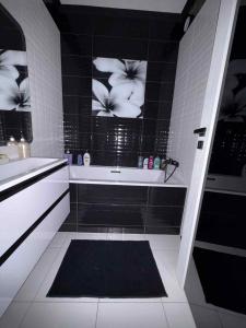a bathroom with a black and white tiled wall at Black&White Deluxe in Miskolc