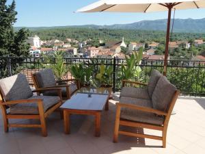 a patio with chairs and a table and an umbrella at Villa Agava in Vrboska