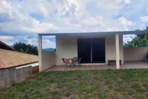 a house with a patio with two chairs and a table at Refugio Stella Container - Aconchegante, Completo e Bem Localizado in Brotas