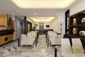 a restaurant with white chairs and a dining room at 陶陶居商旅 Tautauchu Hotel in Hualien City