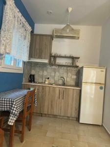 a kitchen with a sink and a refrigerator and a table at Albatross in Marathokampos