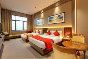 una habitación de hotel con dos camas y una mesa en Boutique Hotel Almate - Near Delhi Airport With - free Airport Pickup, en Nueva Delhi