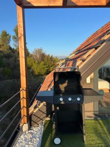 a grill on a deck with a roof at SunnyHill Villa in Shkodër