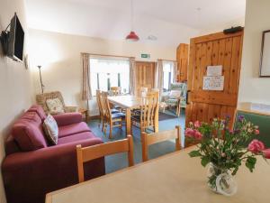 a living room with a couch and a table at Clwyd Special Riding Centre in Ffrith