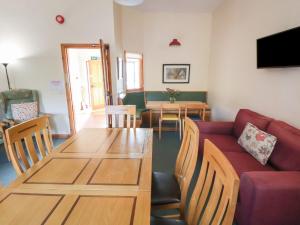 una sala de estar con un sofá y una mesa en Clwyd Special Riding Centre, en Ffrith