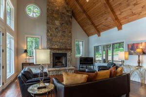 a living room with leather furniture and a stone fireplace at Longview at Eagles Nest in Elk Park