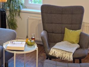 a living room with a chair and a table with a book at Apartment Piepmäker mit Parkplatz und Kamin, Bahnhof fußläufig in Goslar
